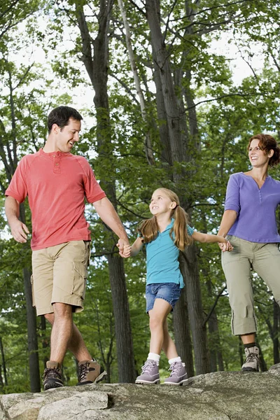 Flickan och föräldrarna går i skogen — Stockfoto