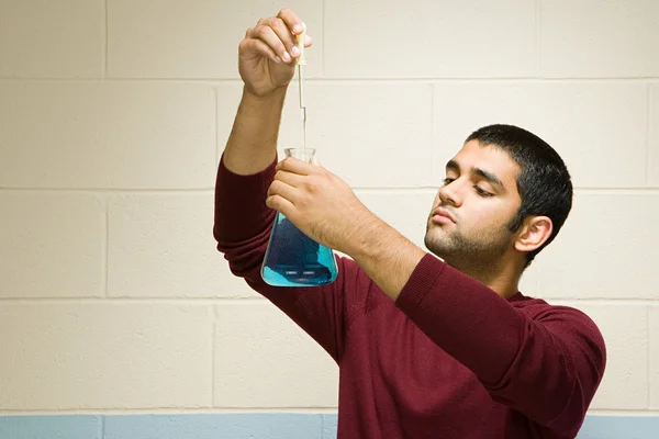 Male student performing an experiment — Stock Photo, Image
