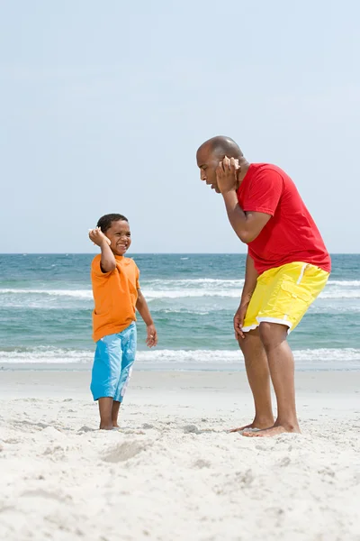 Vader en zoon houden schelpen — Stockfoto