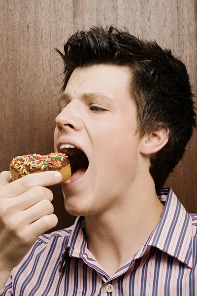 Businessman eating a doughnut — Stock Photo, Image