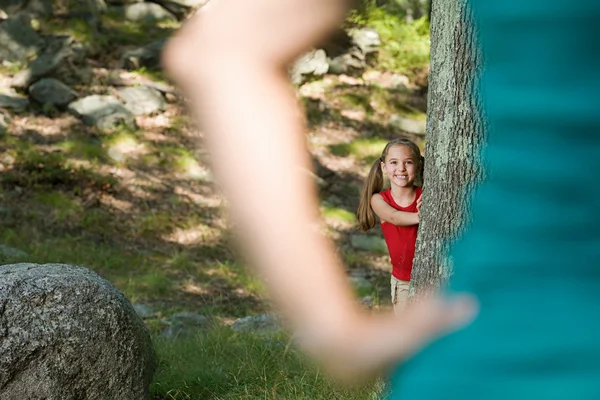 Девушка прячется за деревом — стоковое фото