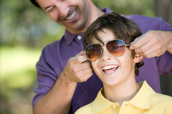 Pai colocando óculos de sol no filho — Fotografia de Stock