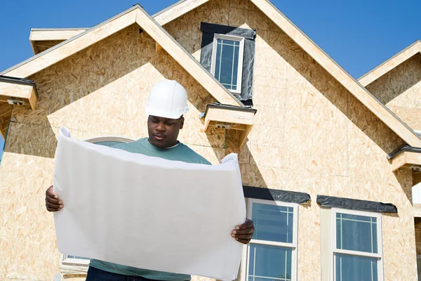 En byggare som håller en plan — Stockfoto