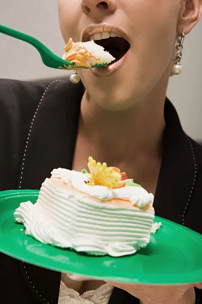 Businesswoman eating cake — Stock Photo, Image