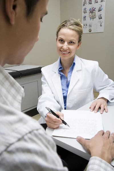 Doctor and patient in doctors office — Stock Photo, Image