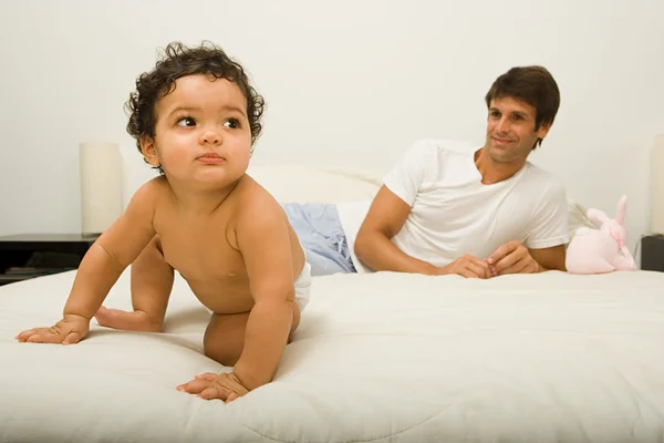 赤ちゃんとベッドの上の父 — ストック写真
