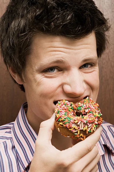 Zakenman eten van een donut — Stockfoto