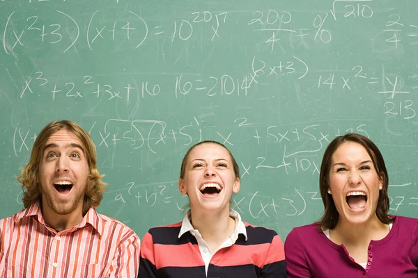 Three students laughing in classroom — Stock Photo, Image