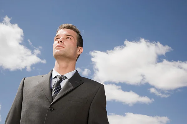 Retrato de um homem de negócios sob nuvens céu — Fotografia de Stock