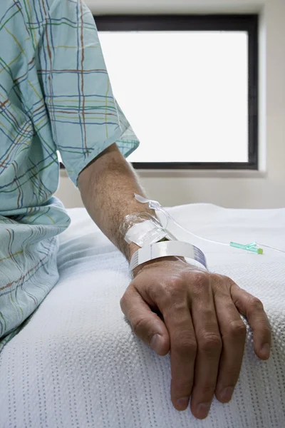 Больничный пациент сидит на кровати — стоковое фото