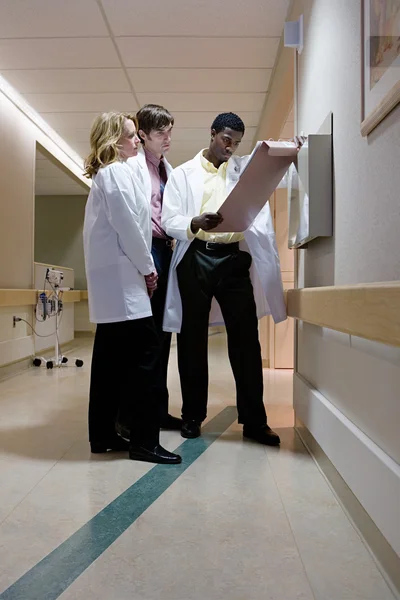Lekarze, patrząc na pacjenta notatki — Zdjęcie stockowe