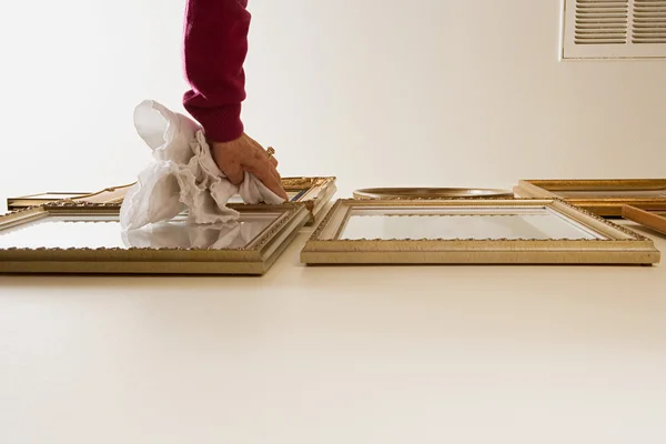 Mulher espanando molduras de imagem — Fotografia de Stock