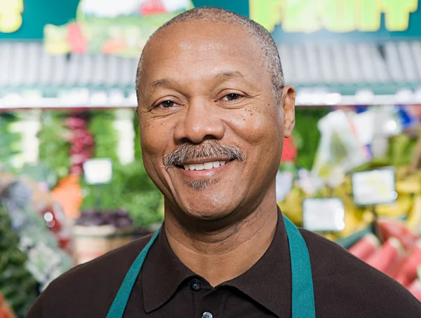 Porträtt av en grönsakshandlare leende — Stockfoto