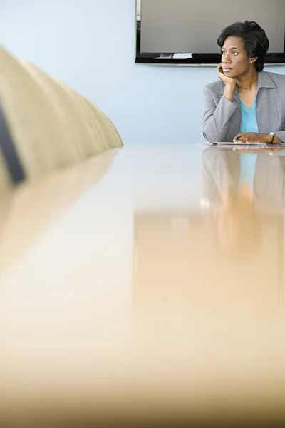 Businesswoman sitting and thinking in boardroom — Stock Photo, Image