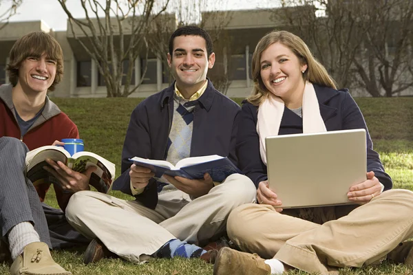 Trois étudiants assis à l'extérieur — Photo