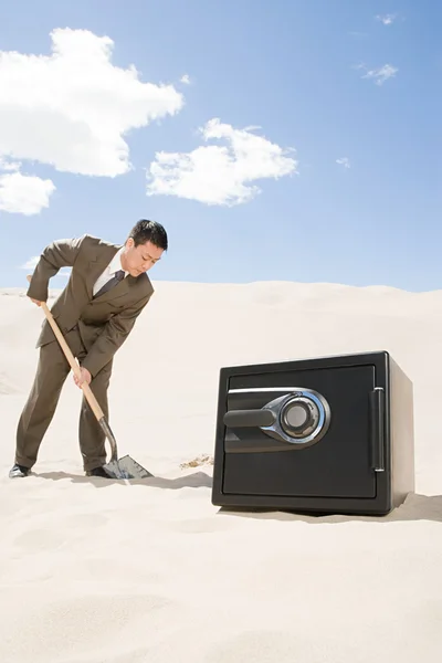 Homem cavando por cofre no deserto — Fotografia de Stock