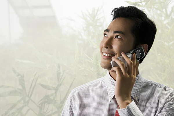 Молодой бизнесмен пользуется сотовым телефоном — стоковое фото