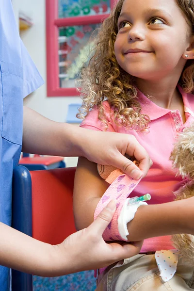 Krankenschwester legt Mädchen Verband an — Stockfoto