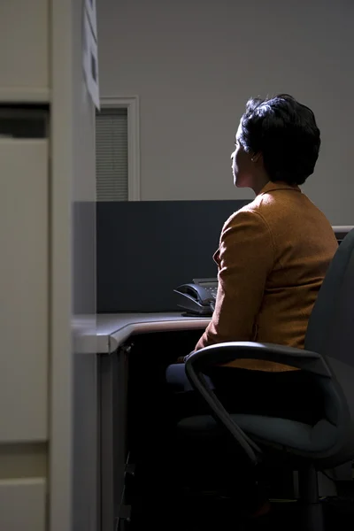 Woman thinking in dark office — Stock Photo, Image