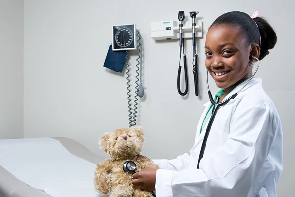 Menina médico usando estetoscópio no ursinho de pelúcia — Fotografia de Stock