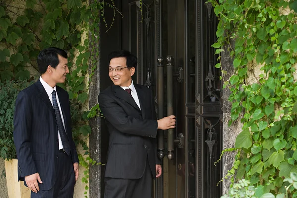 Des hommes d'affaires chinois devant une maison — Photo