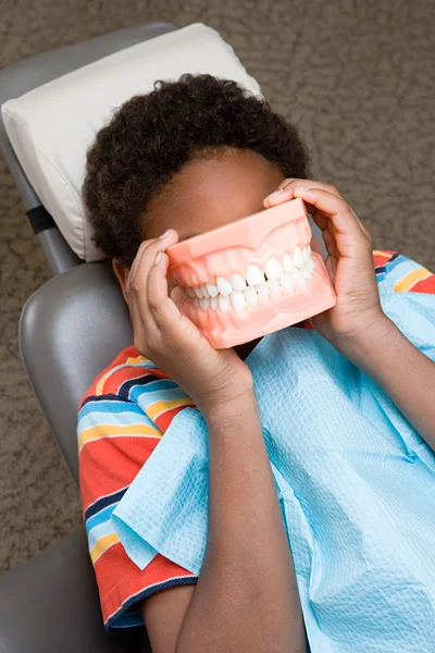 Boy covering face with false teeth — Stock Photo, Image