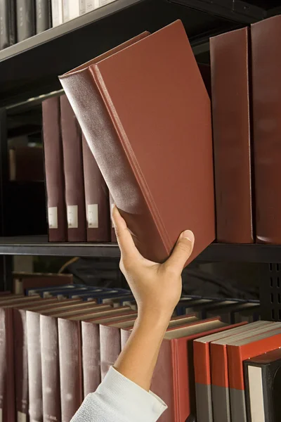 Female student reaching for a book — Stock Photo, Image