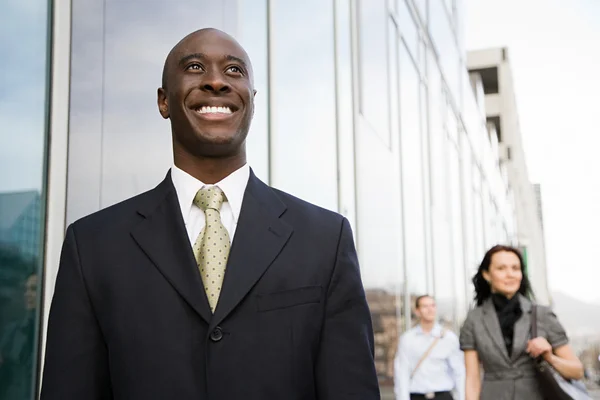 Businessman smiling on city street — Stock Photo, Image