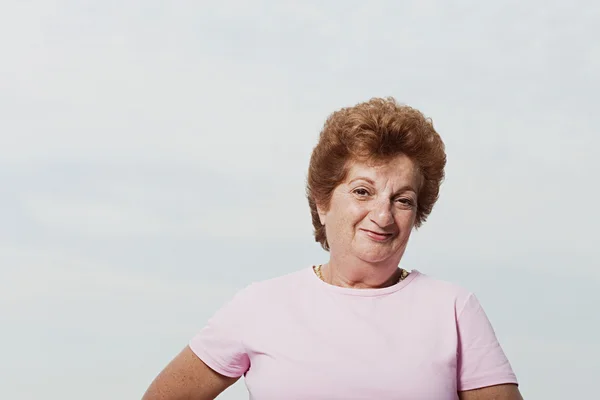 Starszy kobieta nosi różowy t-shirt — Zdjęcie stockowe