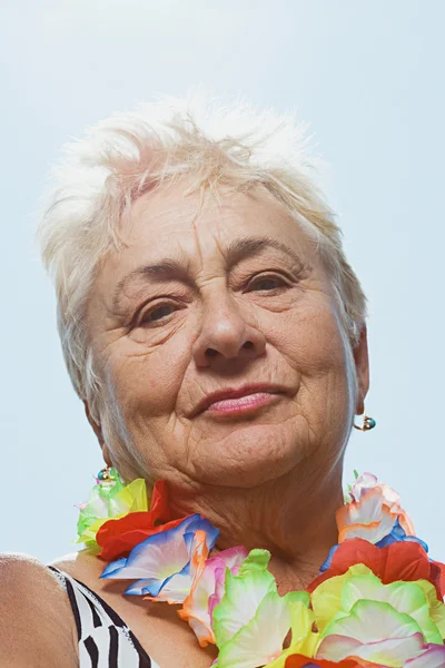 Senior vrouw dragen een vloeiende garland — Stockfoto