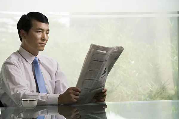 Chinese businessman reading a newspaper — Stock Photo, Image