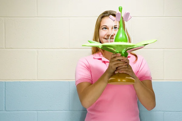 Female student holding a model of a plant — Stock Photo, Image