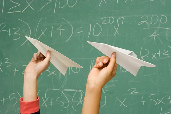 Två studenter omkring till kasta papper flygplan — Stockfoto
