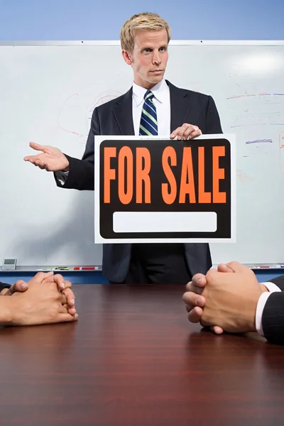 Businessman holding for sale sign — Stock Photo, Image