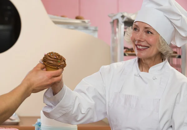 Szef kuchni z cupcake uśmiechający się — Zdjęcie stockowe