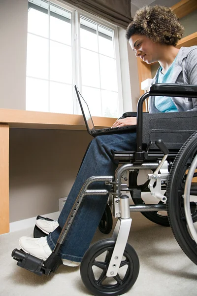 Mulher com deficiência usando um computador portátil — Fotografia de Stock