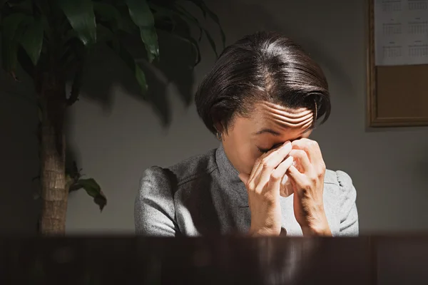 Businesswoman crying in a dark office — Stock Photo, Image