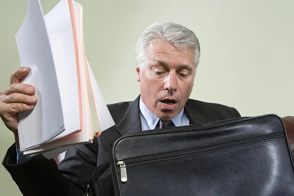 Panicked man looking in briefcase — Stock Photo, Image