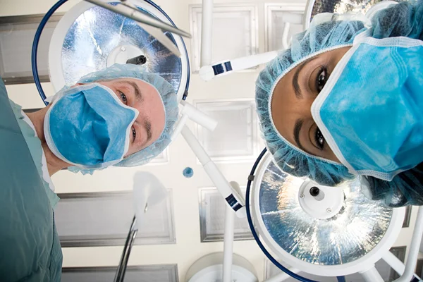 Les chirurgiens regardent vers le bas sur le patient — Photo
