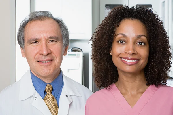 Dentist and dental nurse smiling — Stock Photo, Image