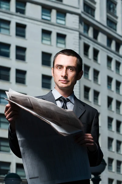 Businessman with newspaper in city — Stock Photo, Image