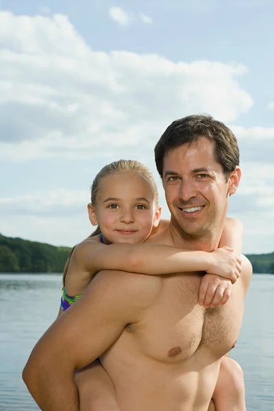 Far gir datter en runde tilbake. – stockfoto