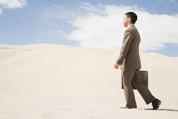 Businessman walking in the hot desert — Stock Photo, Image