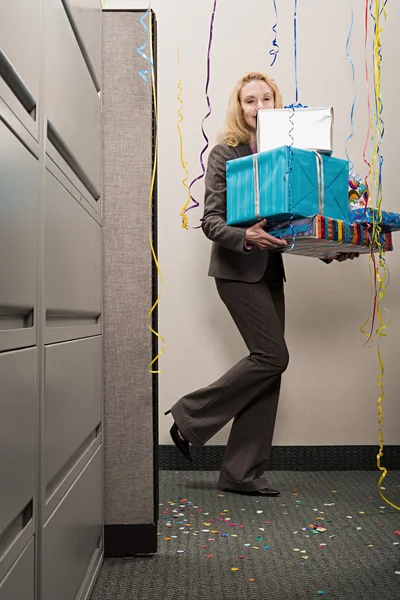 Businesswoman carrying pile of presents — Stock Photo, Image