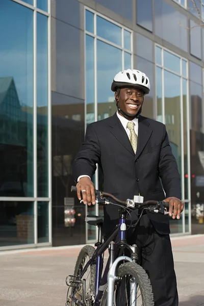 Affärsman med cykel bära hjälm leende — Stockfoto