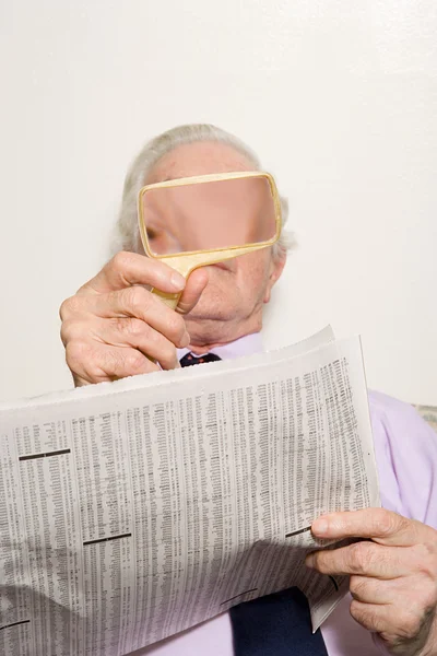 Hombre leyendo periódico con lupa —  Fotos de Stock