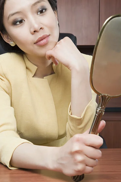 Businesswoman looking at mirror — Stock Photo, Image