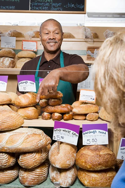 Baker che serve il cliente in negozio — Foto Stock