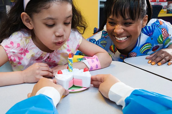 Girl and nurses with toy birthday cake — Stock Photo, Image