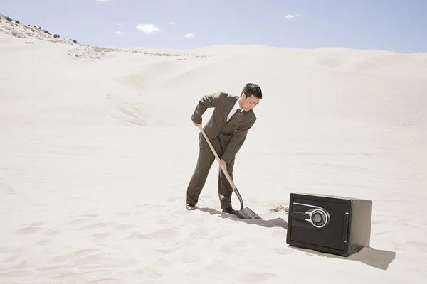 Homem cavando por cofre no deserto — Fotografia de Stock